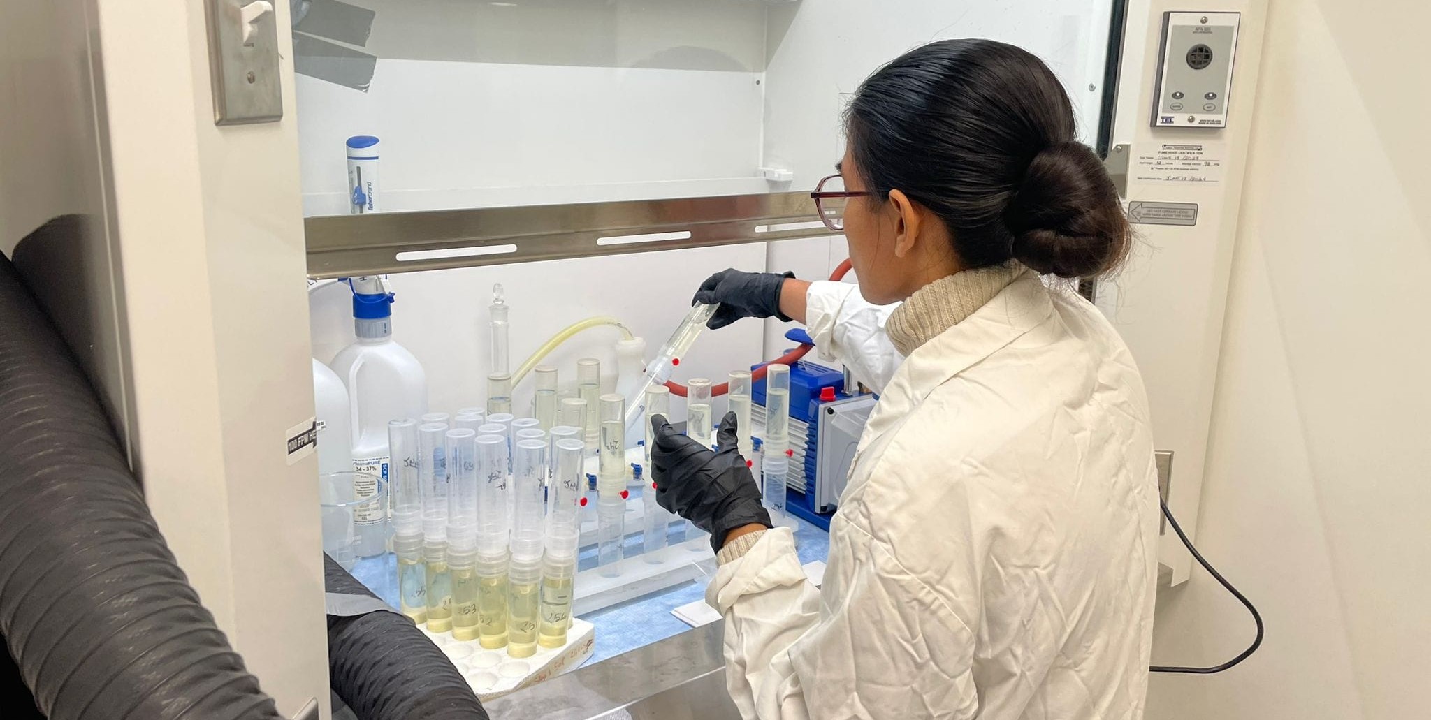 A woman handling test tubes in a lab